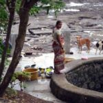 A village woman in Elephanta cleans household utensils at a well that barely contains any water. (Photo by Gajanan Khergamker)