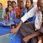 Residents of Adakata village listen to a program on community radio. (Photo by Basudev Mahapatra)