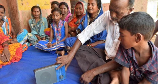 Residents of Adakata village listen to a program on community radio. (Photo by Basudev Mahapatra)