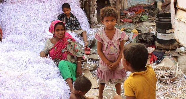 In a roadside ghetto, Akila Bibi and others after a day’s hard work, separating white paper shreds from the colored ones for recycling. Earning Rs 3 a kg, they manage 30 kg to 50 kg a day. (Photo by Manipadma Jena)