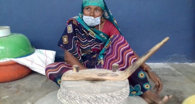A woman uses jata, a traditional grinding stone, to make sattu. (Photo by Mohd Imran Khan)