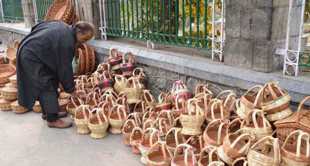 A vendor arranging kangris for sale on a footpath in a Srinagar market. (Photo by Athar Parvaiz)