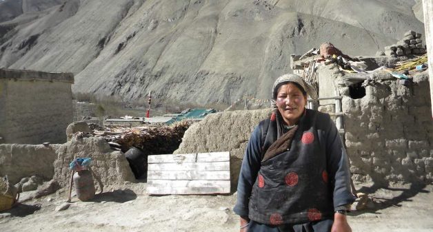 Tashi Tsonma of Rumbak Village fetches hot water from a solar heater. (Photo by Sharada Balasubramanian)