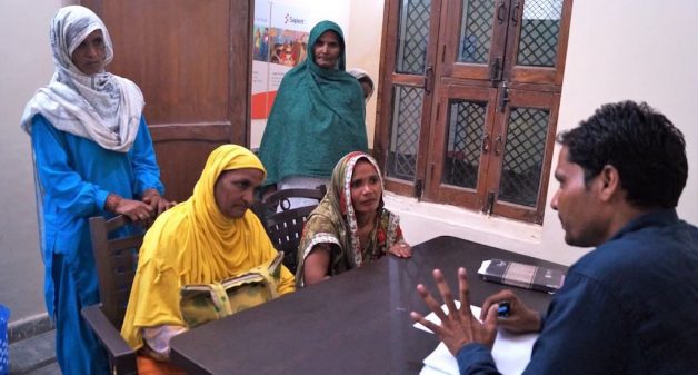 Mohammad Sabir of CISC guides woman villagers, helping them seek government benefits, as a first step towards empowering them (Photo by Tarun Kanti Bose)