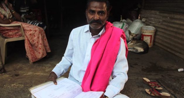 Lakshman Helavar, a traditional chronicler of family histories, with his carefully preserved genealogical records (Photo by Amoolya Rajappa)