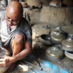 A brass smith beats into shape a traditional brass pot that is no longer in demand (Photo by Gurvinder Singh)