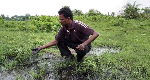 Kirodha Das shows the coal washery water from the Talcher industrial hub laced with pollutants entering the villages and farmlands (Photo by Manish Kumar)