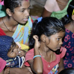 Children and women attending an awareness meeting on hot iron branding
